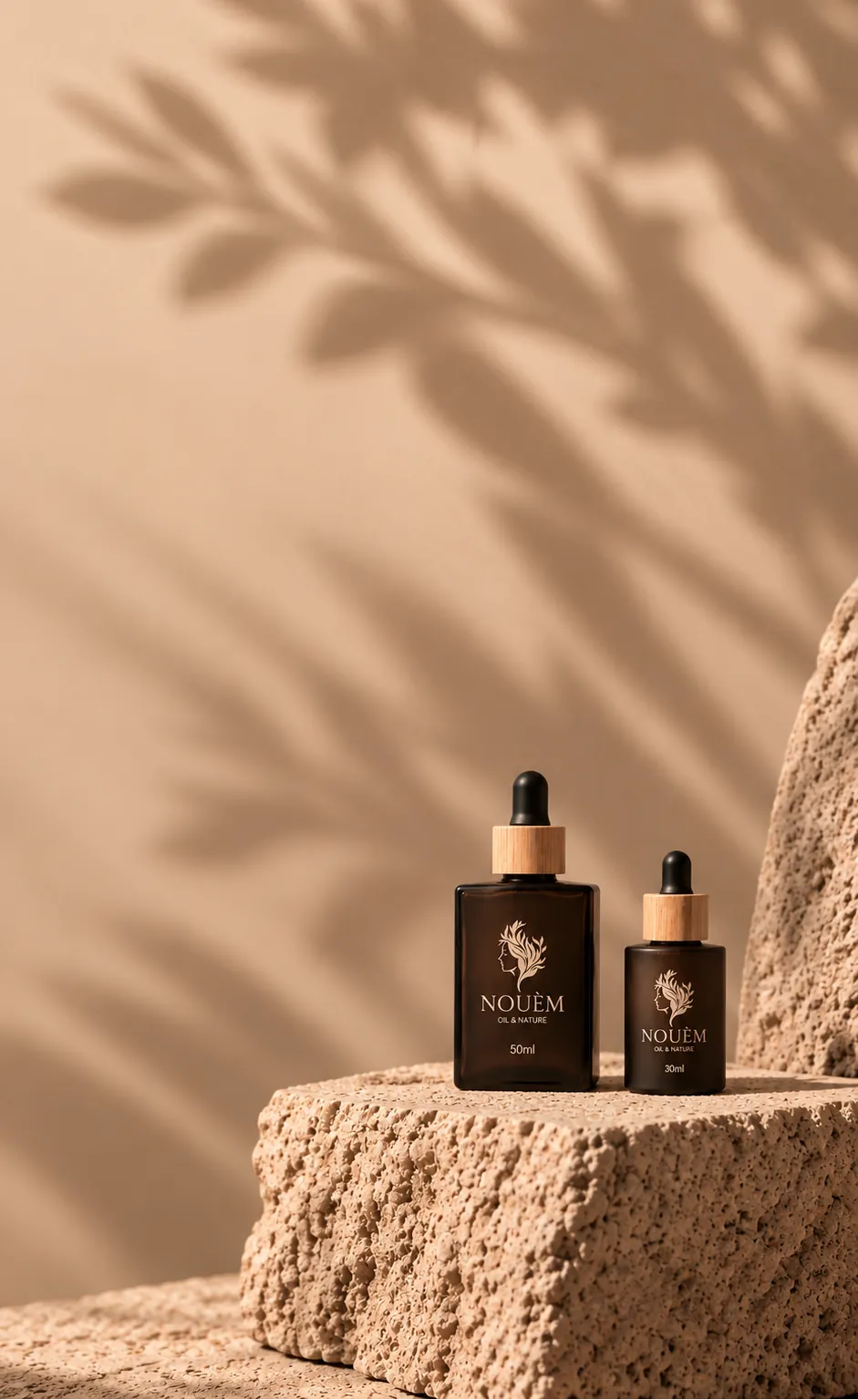 Two Nouèm Oil & Nature oil bottles on natural stone in warm sunlight
